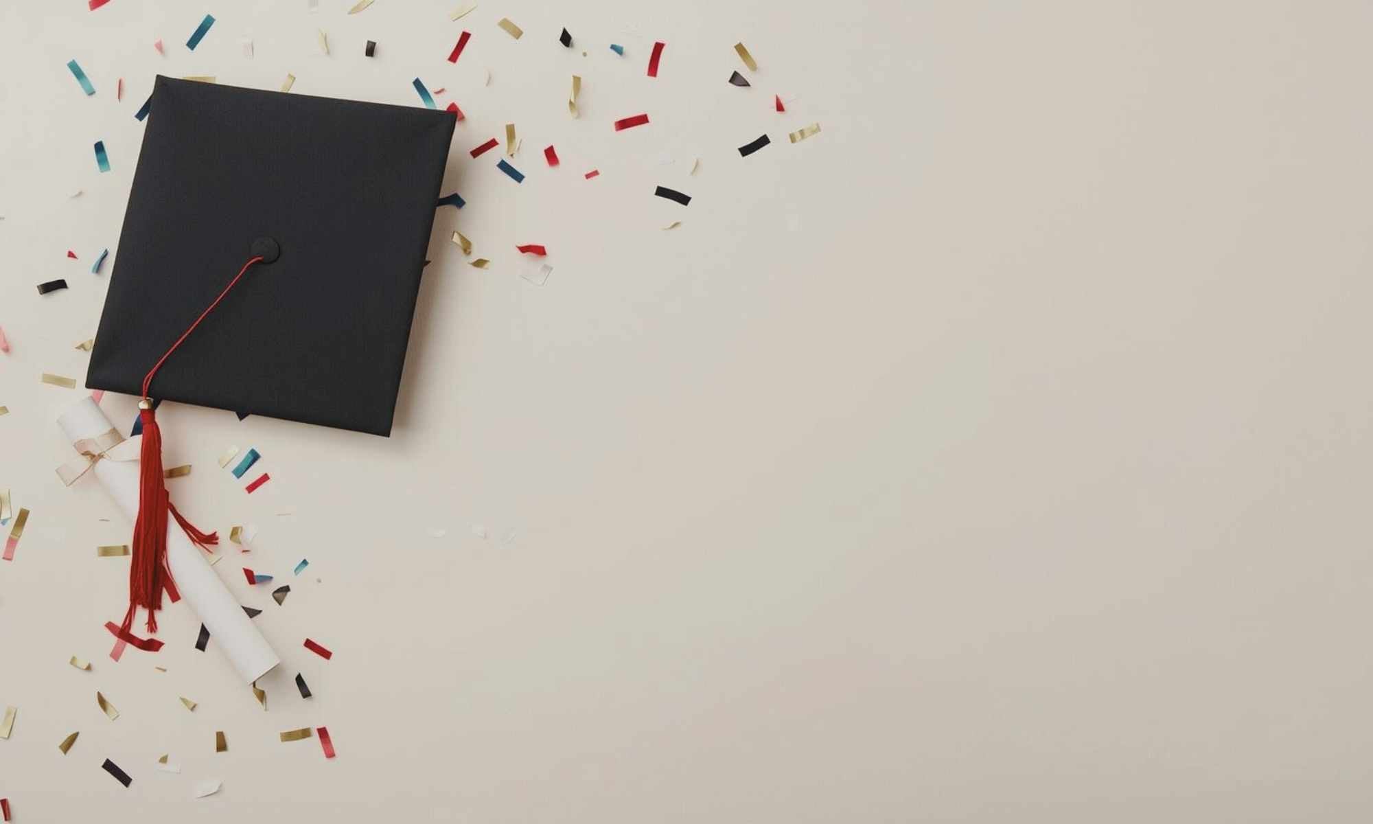 image of graduation cap on neutral surface with confetti