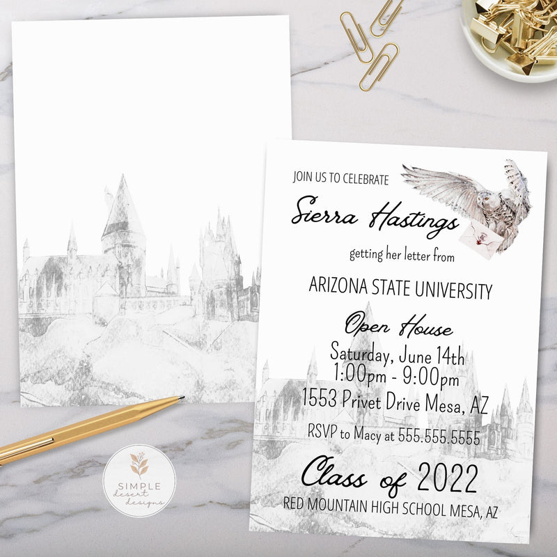 Graduation invitation with owl carrying envelope with maroon wax seal flying over a castle design on a marble surface with stationery items.