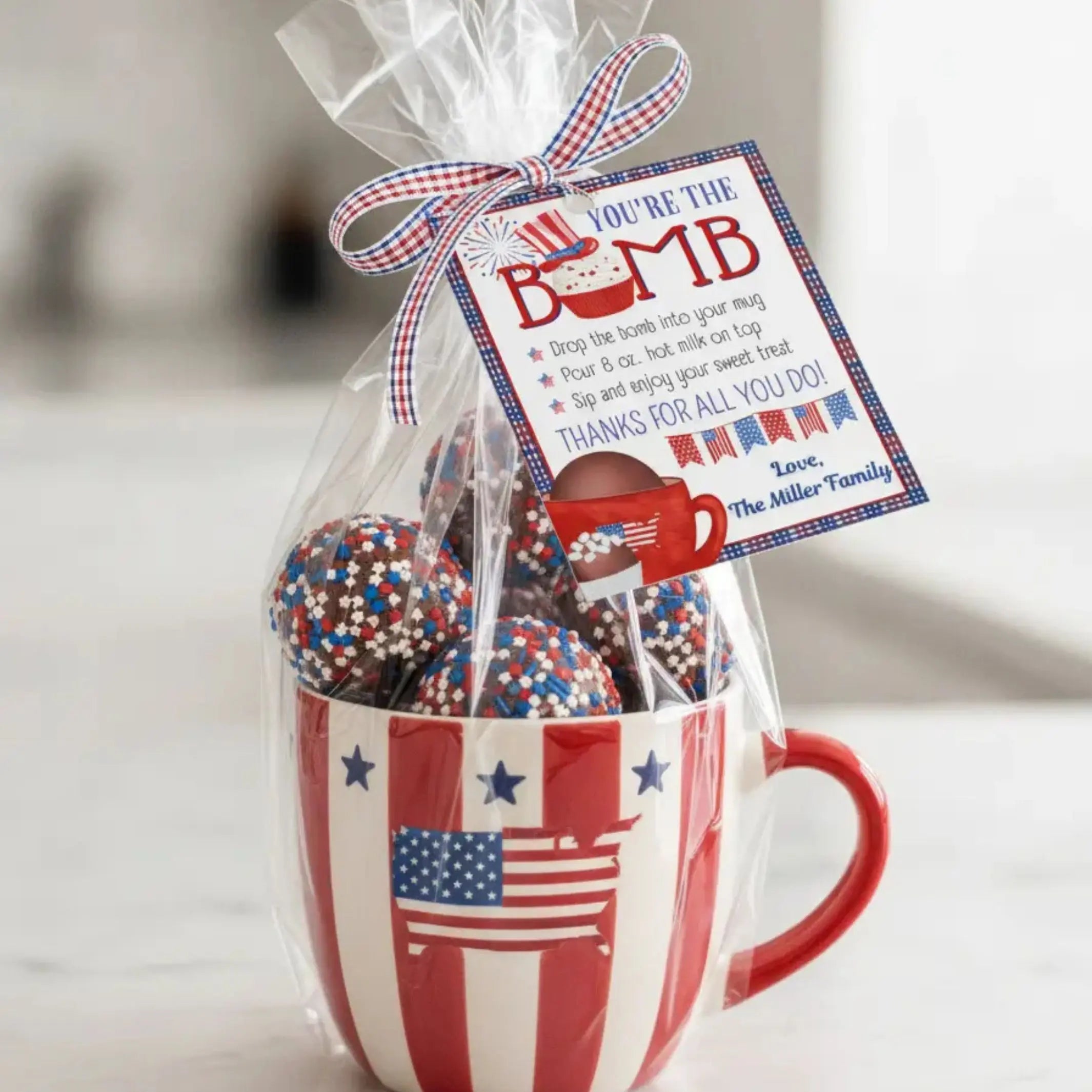 Red, white, and blue gift set with a mug and decorative items, featuring an editable  'You're the Bomb' patriotic gift tag.
