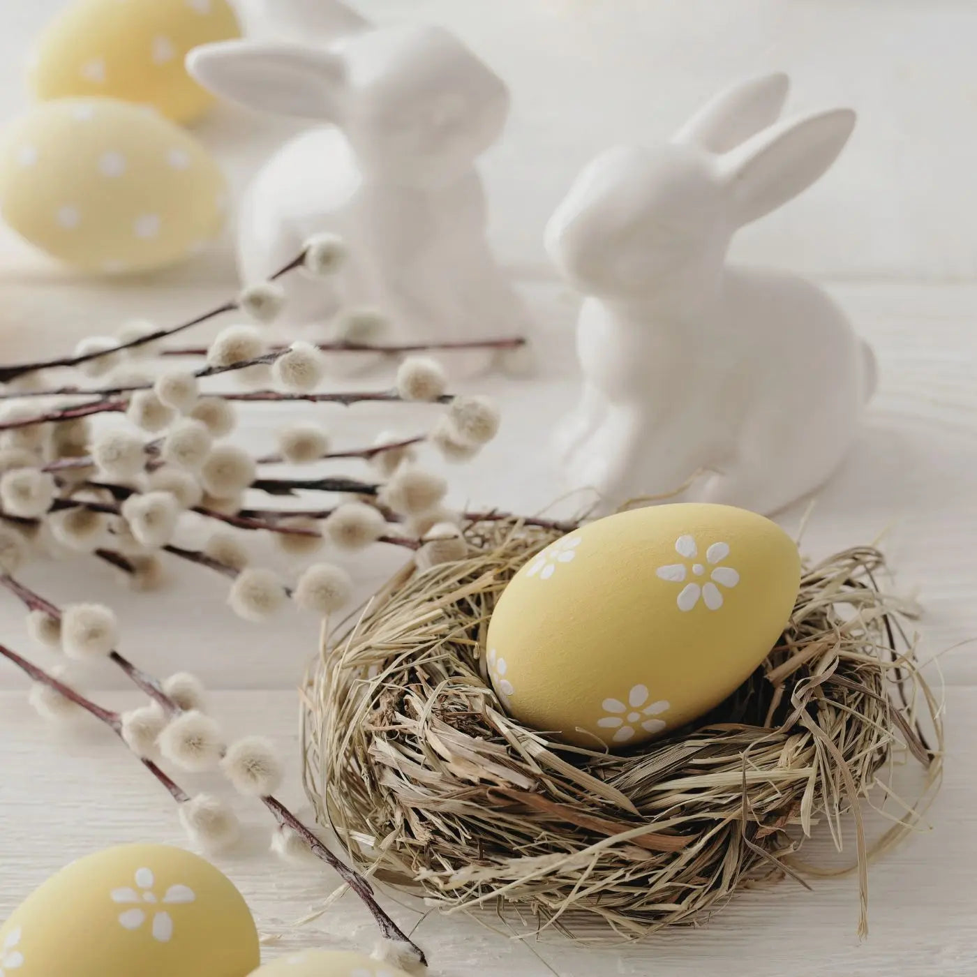 Decorative Easter scene with yellow eggs, white rabbits, and a nest on a light background representing editable invitations, flyers, tags, and event bundle templates by Simple Desert Designs.