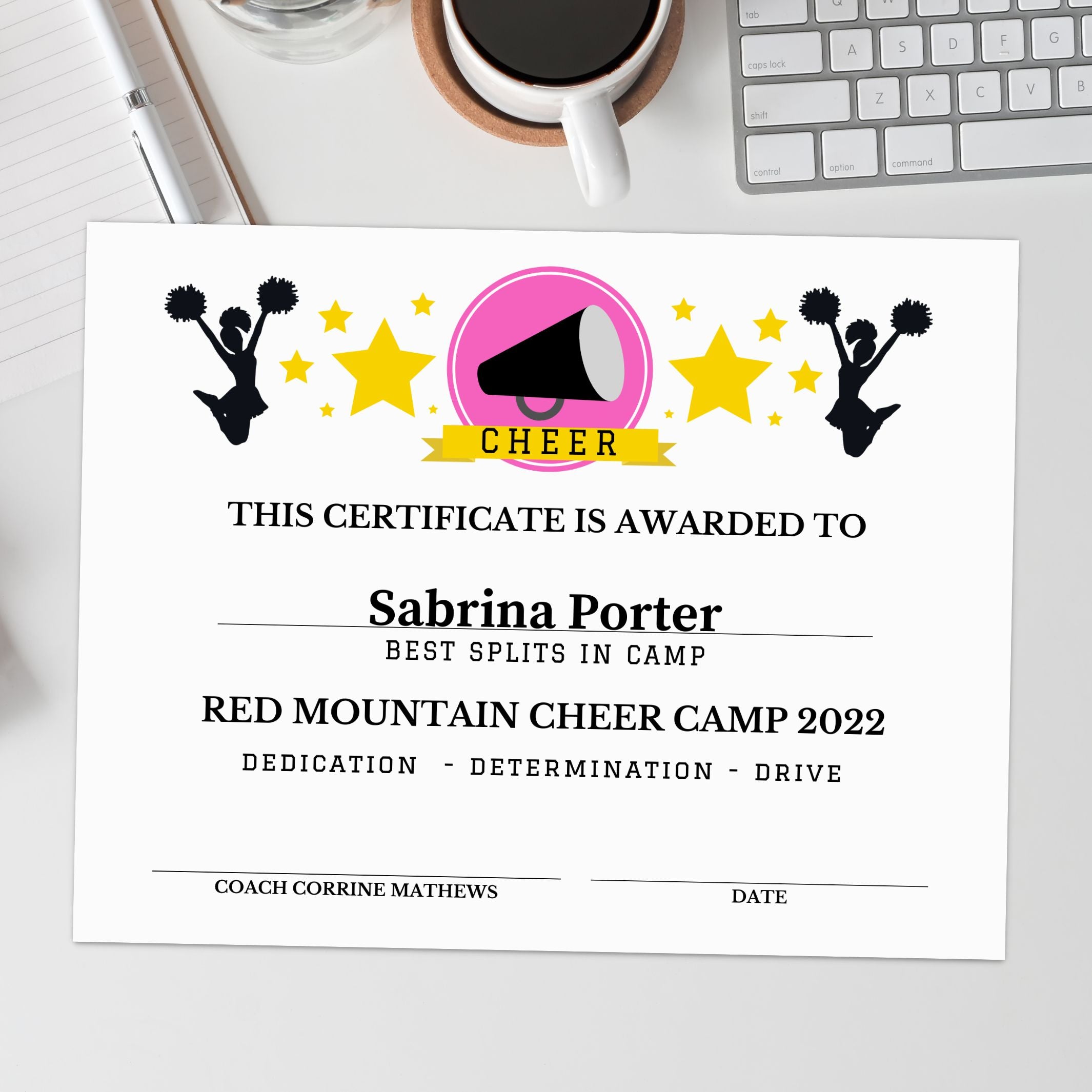 Certificate for Sabrina Porter from Red Mountain Cheer Camp 2022 on a desk with a coffee cup and laptop.