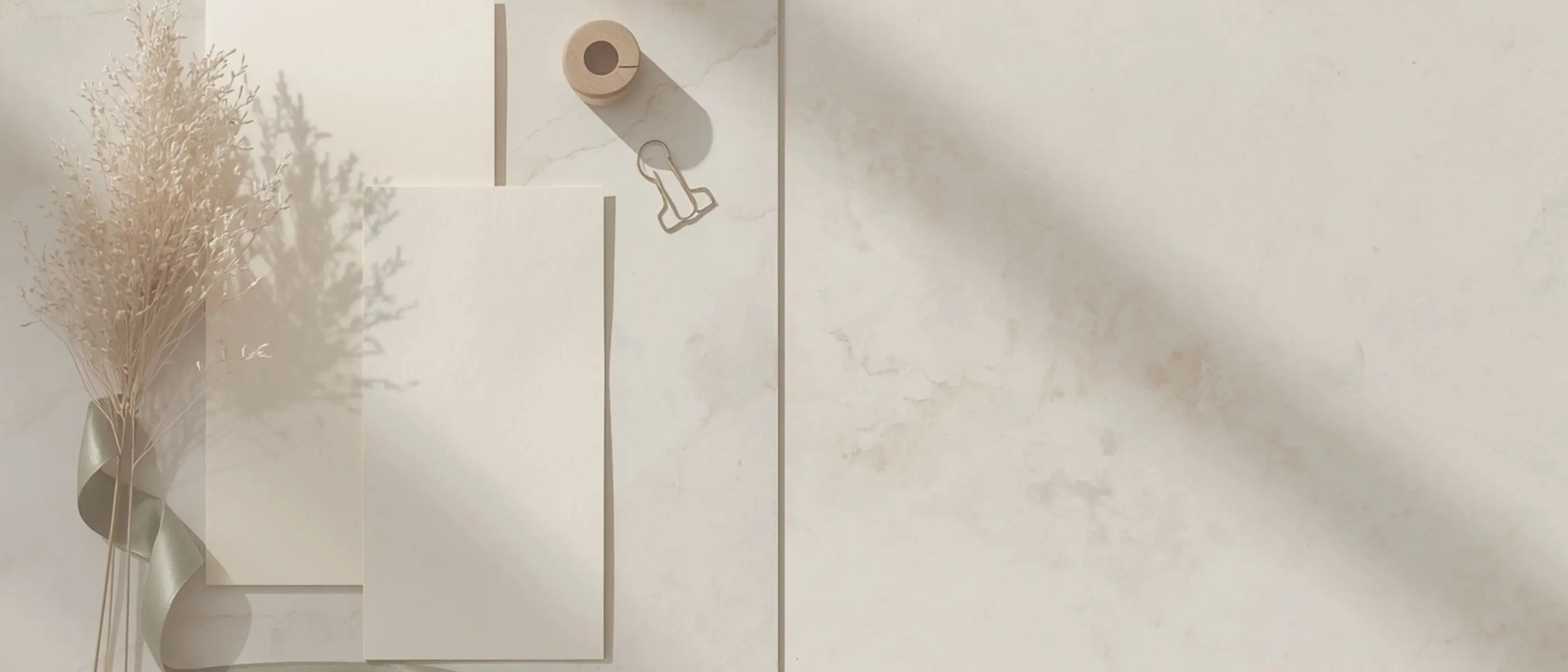 A professional event design suite with cream stationery, sage silk ribbon, and a brass paperclip on a stone table, representing coordinated invitations, gift tags, and editable templates for showers and office events.