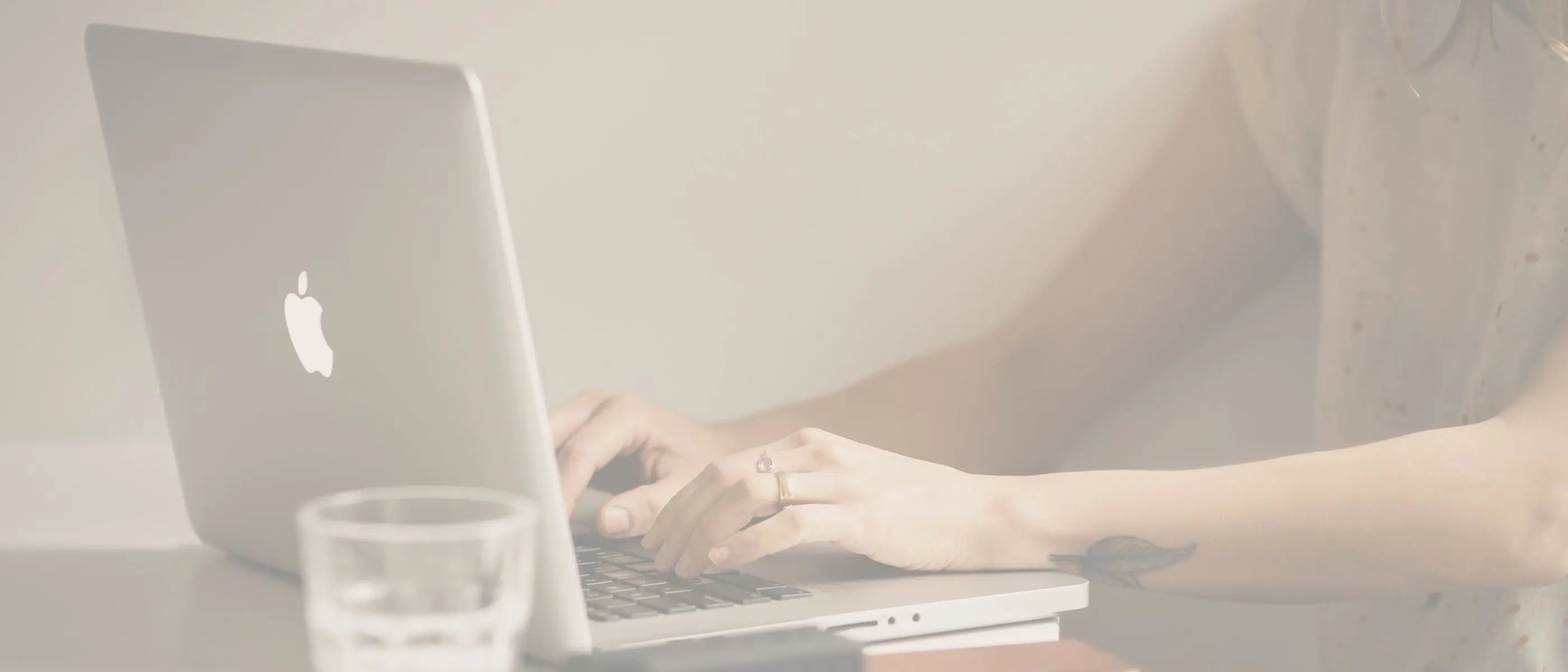 Person using a laptop on a light background representing a page of free resources by Simple Desert Designs.