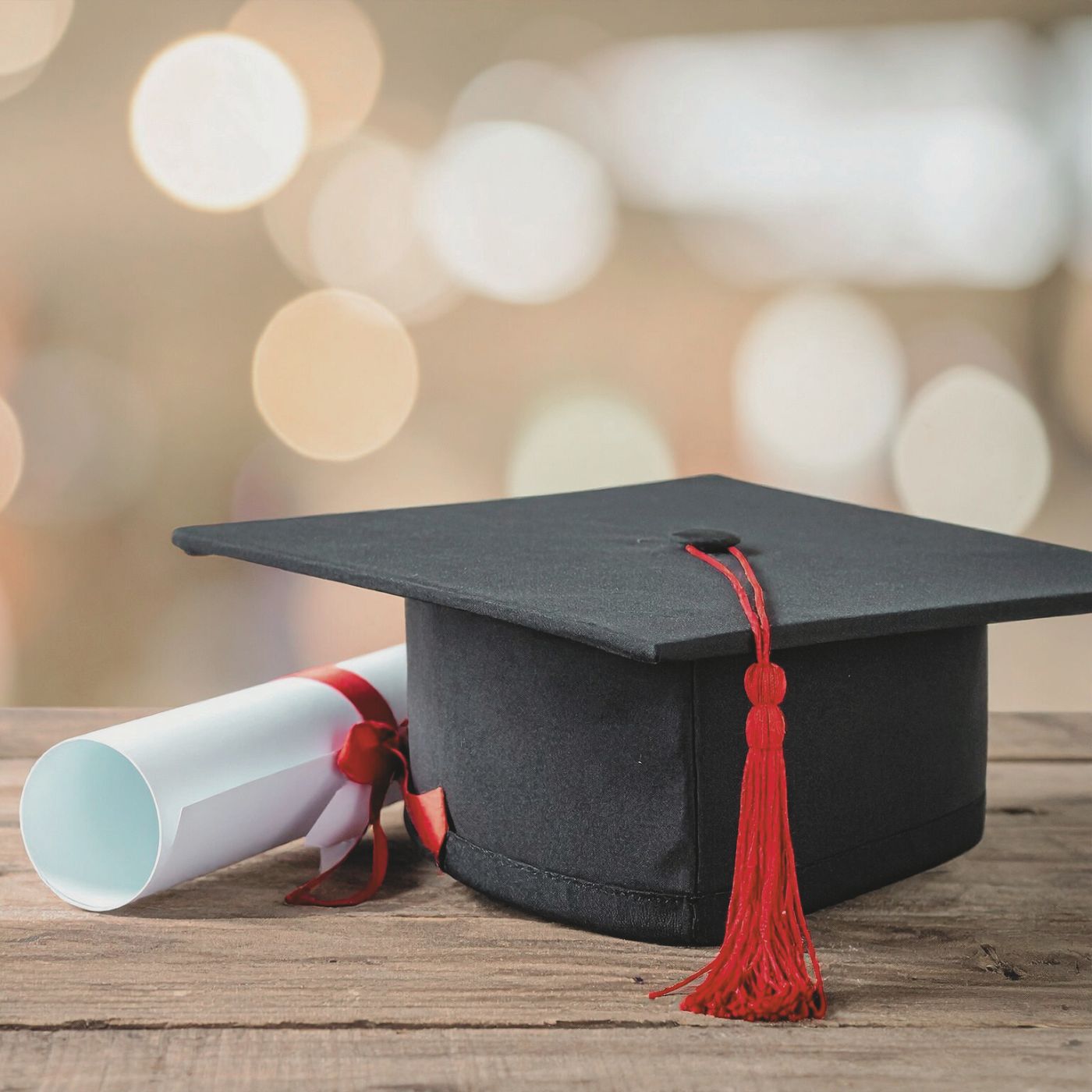 graduation cap and diploma on wood surface with soft lighting