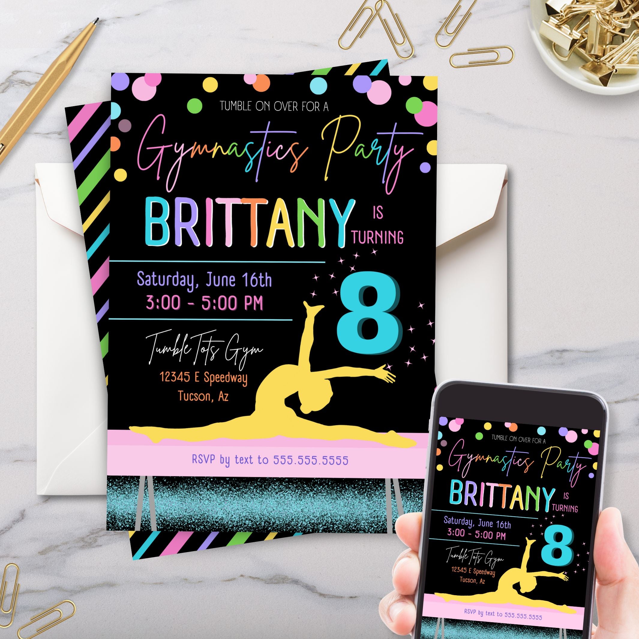 colorful gymnastics birthday party invitation with girl on balance beam shown on white marble surface and phone with gold paperclips and pen