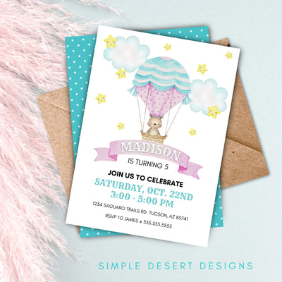 cute hot air balloon birthday invite for little girl on table with pink boho decor