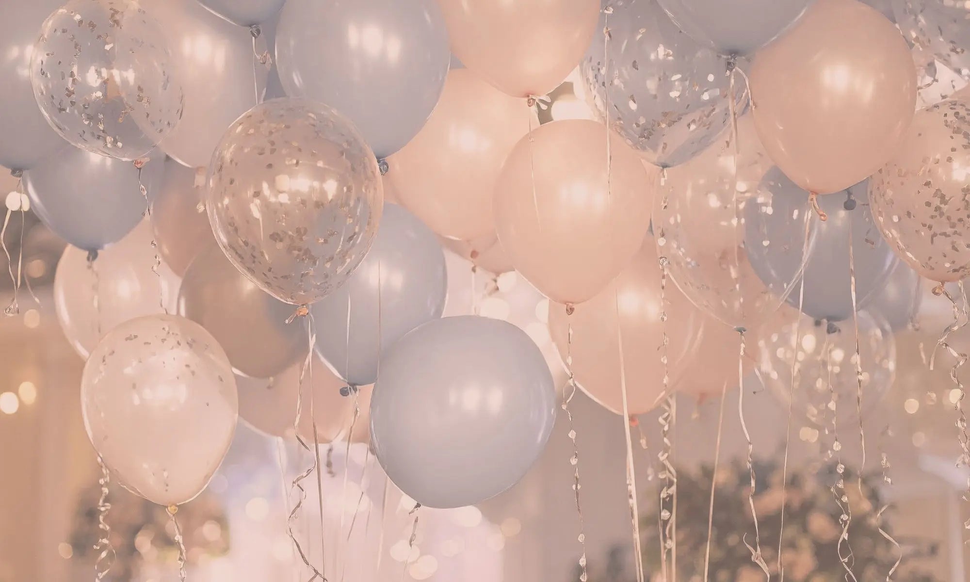 Decorative balloons in pastel colors with confetti and string lights.