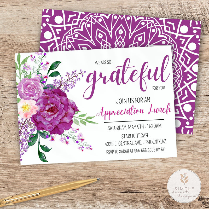 Invitation card with purple floral design and geometric pattern on a wooden surface.