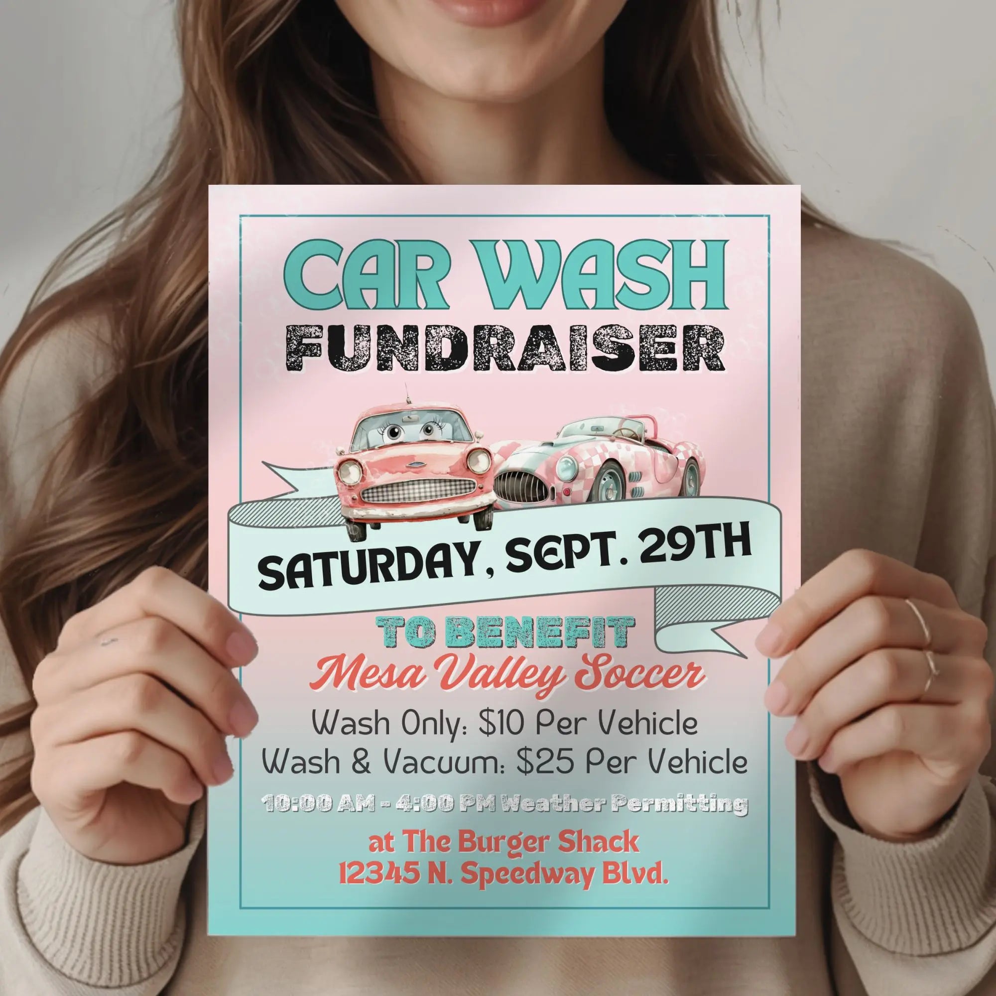 Woman holding a pink and teal green retro style car wash flyer with retro 50s aesthetics representing the editable template for fundraiser flyers.