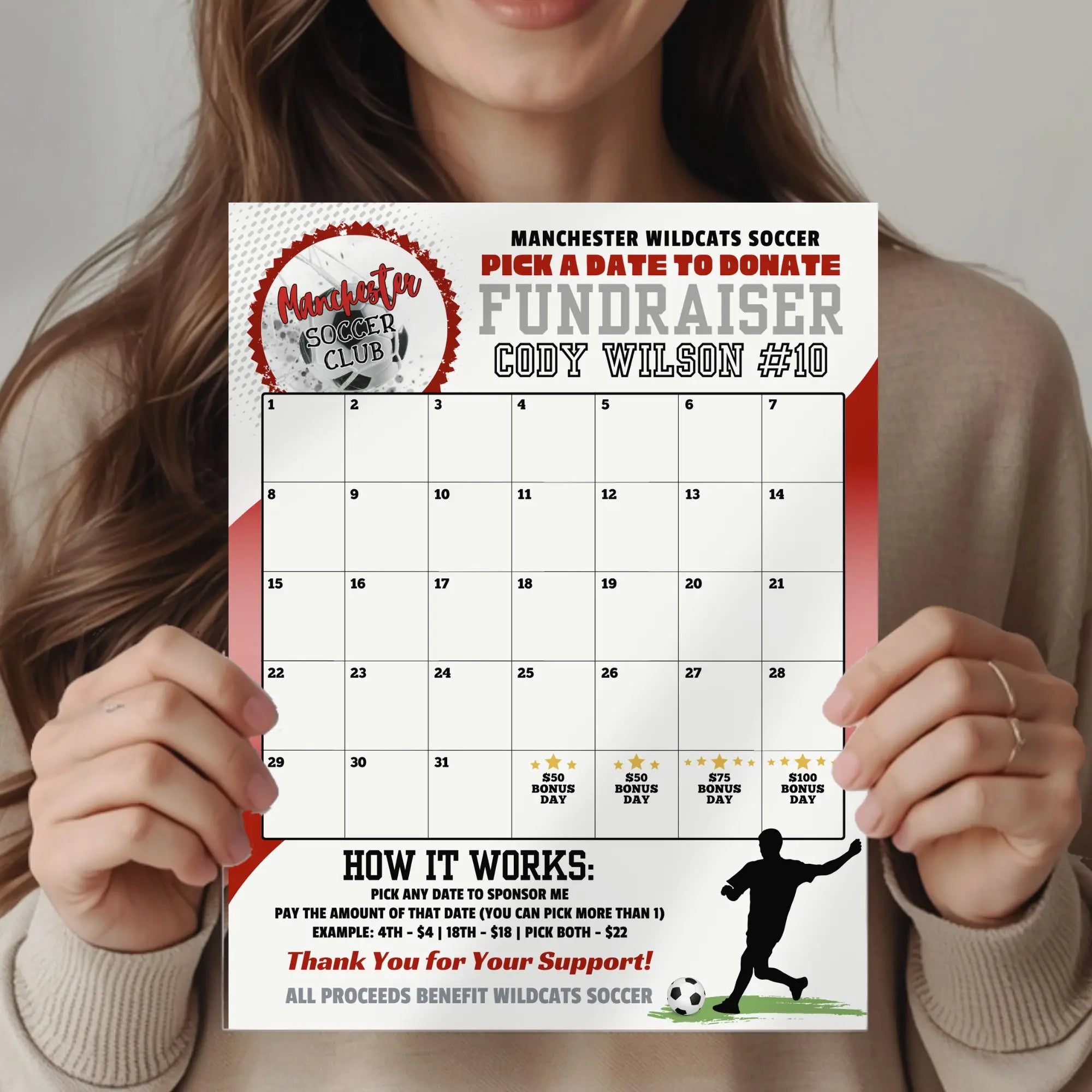 Person holding an edited Manchester Wildcats Soccer fundraiser calendar template customized in red with club logo.