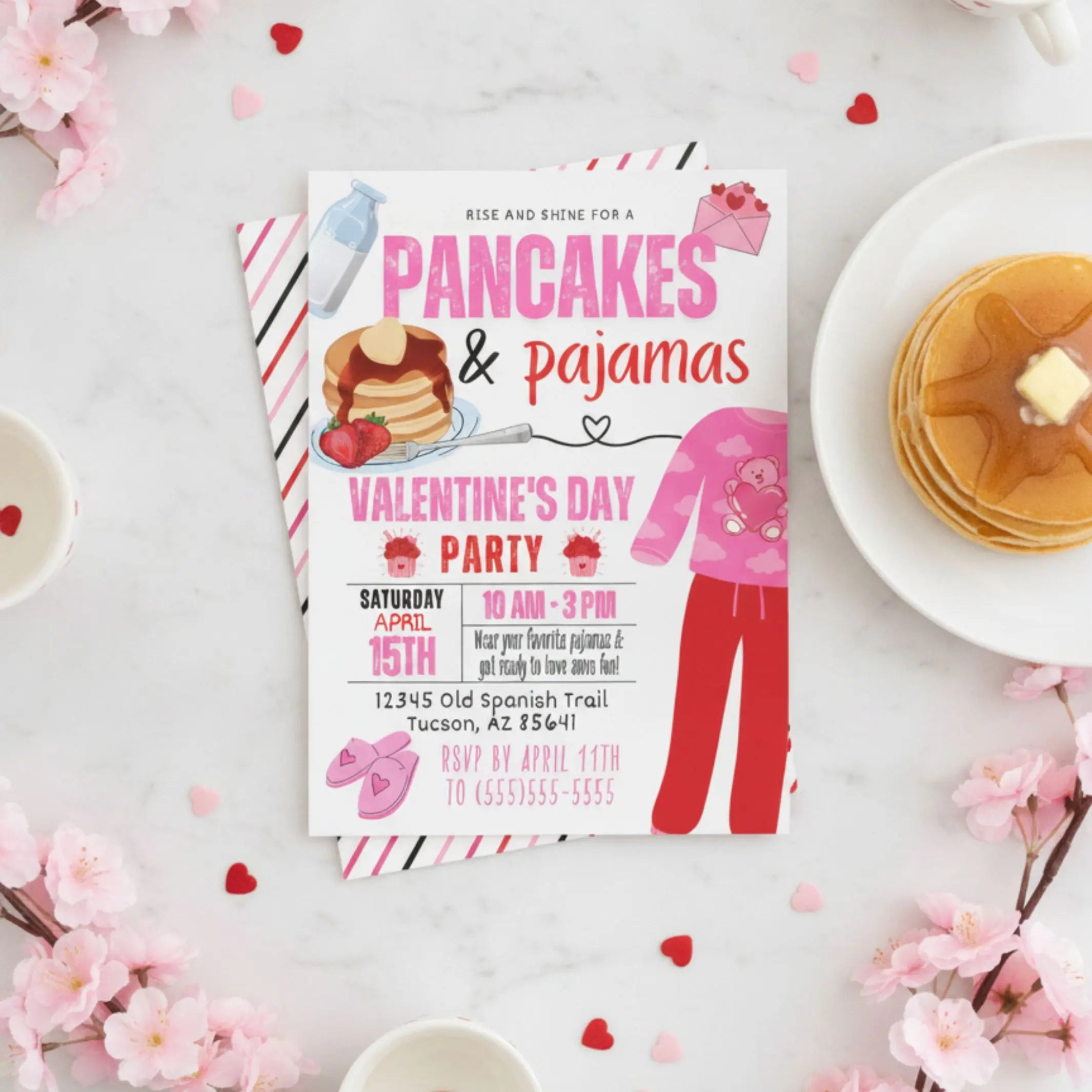 Valentine's Day party invitation with pancakes and pajamas theme on a table with flowers and plates.